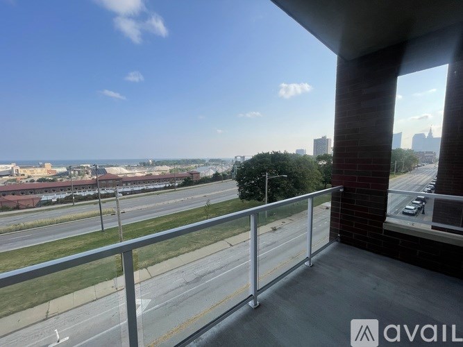 A balcony with a metal railing overlooks a highway with multiple lanes of traffic.