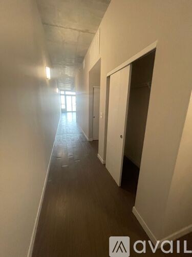 A long hallway with doors on both sides and a light at the end.