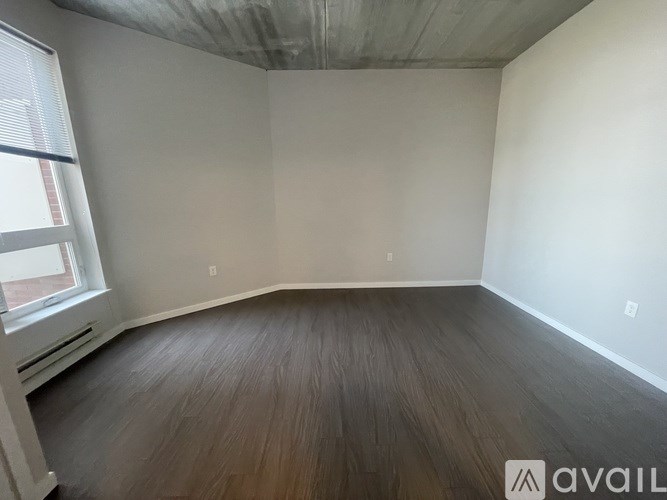A room with wooden flooring and a window.