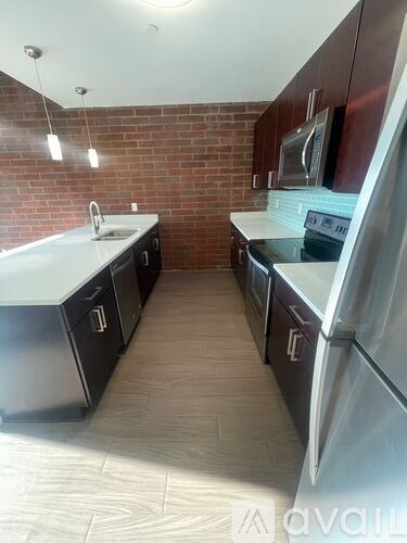 A kitchen with a refrigerator, sink, and microwave.