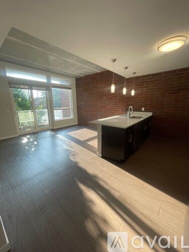 A kitchen with a brick wall and a large window.