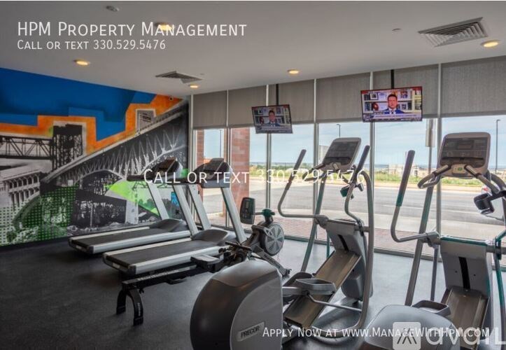 A gym with treadmills and a sign for HPM Property Management.
