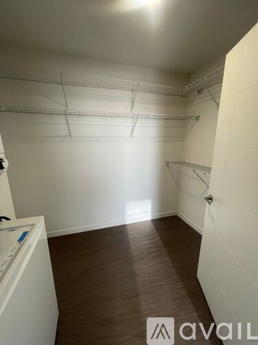 A room with white walls and brown flooring.