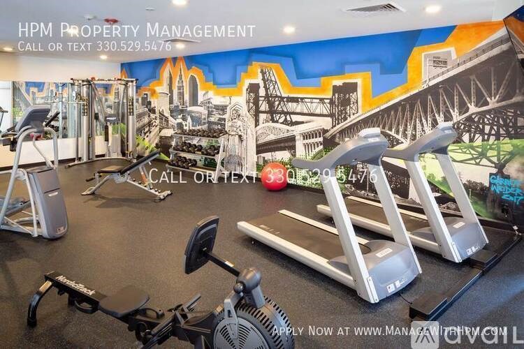 A gym with a variety of equipment including treadmills, weights, and exercise machines.