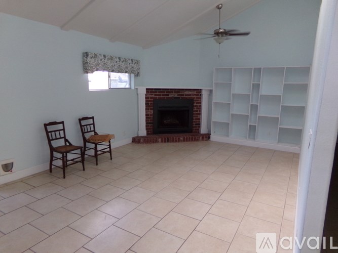 Two chairs are placed in a room with a fireplace.