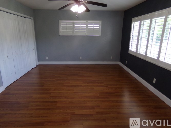 A room with wooden floors and a ceiling fan.