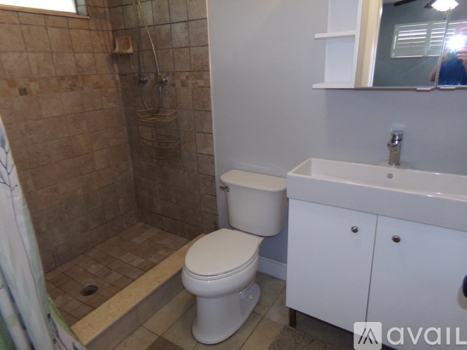 A bathroom with a toilet, sink, and shower.