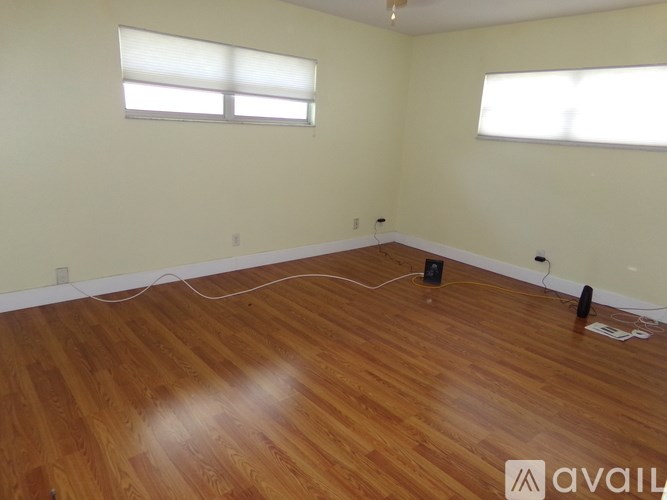 A room with wooden floors and two windows.