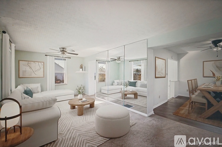 A living room with a white couch, a coffee table, and a glass partition wall.