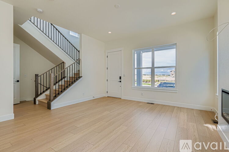 A spacious living room with a staircase leading to the upper floor.