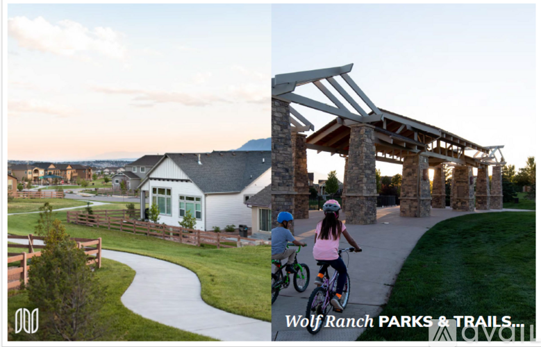 A park with a white building and a bridge with two children riding bikes.