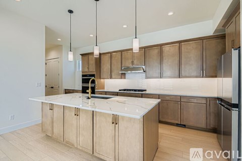 A kitchen with wooden cabinets and a marble countertop.
