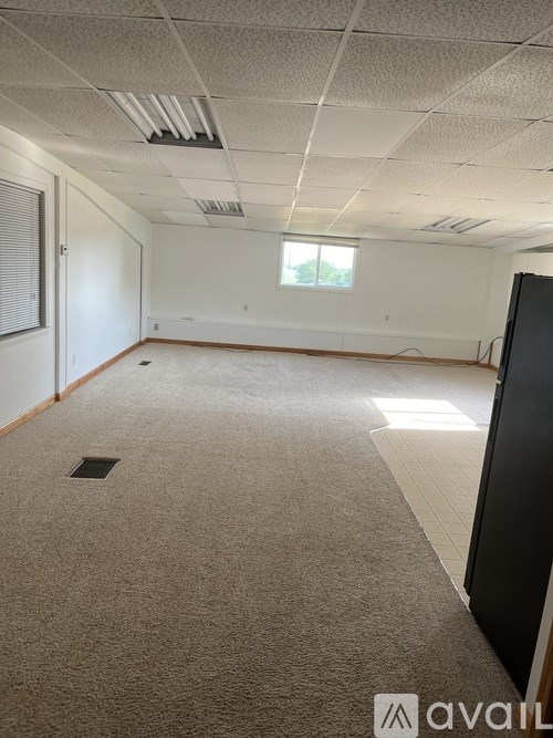 A room with a carpeted floor and a window.