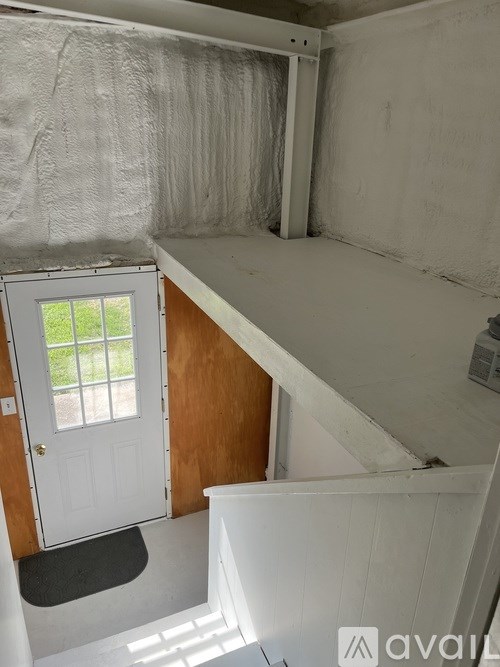 A room with a door and a window covered in plastic.