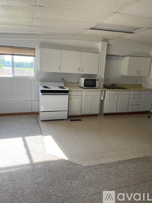 A kitchen with white cabinets and appliances.