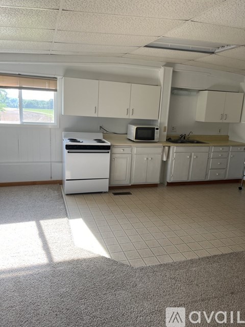 A kitchen with white cabinets and appliances.