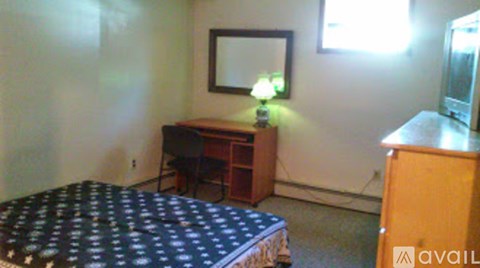 A bedroom with a bed, desk, and chair.