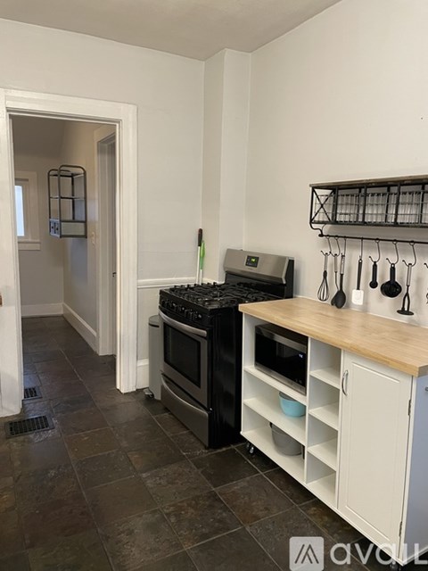 A kitchen with a black stove top oven and white cabinets.