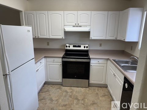 A kitchen with white appliances and cabinets.