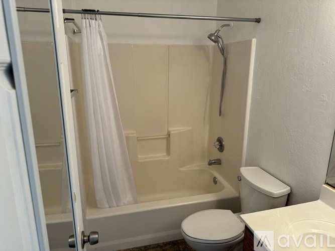 A room with a carpeted floor and a window with blinds.