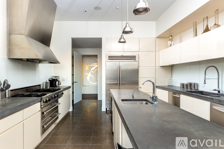A modern kitchen with a large island and stainless steel appliances.