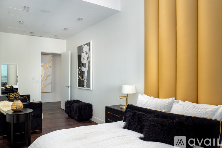 A bedroom with a large bed and a painting on the wall.