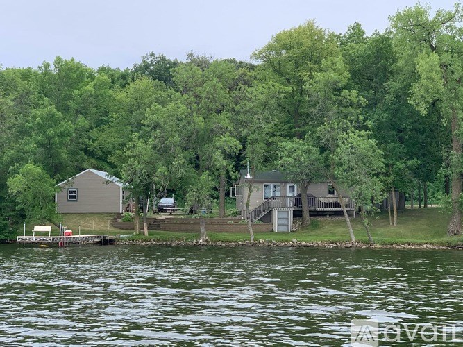 A house is situated on a lake surrounded by trees.
