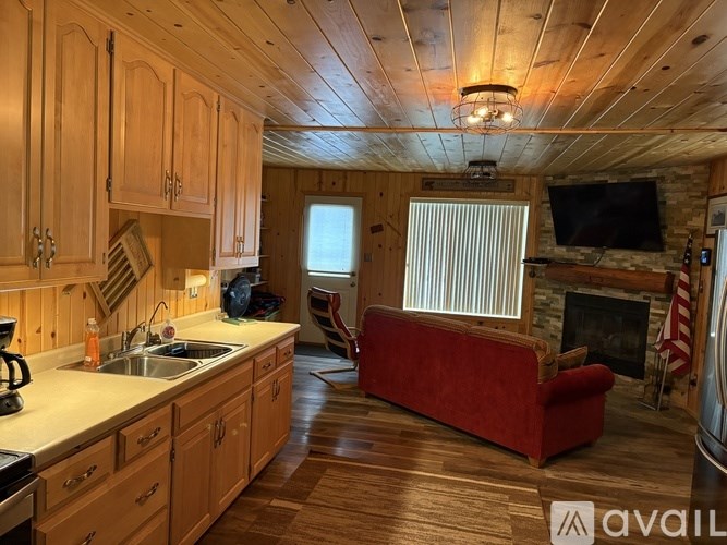 A kitchen with wooden cabinets and a red couch.
