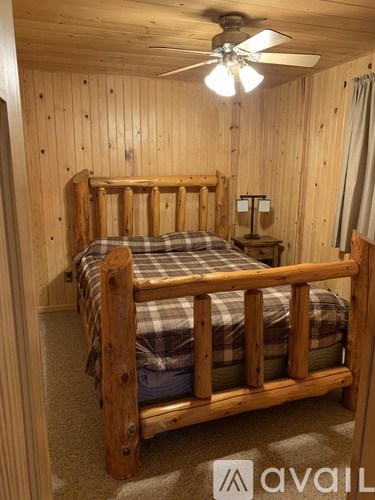 A bedroom with a bed and a ceiling fan.