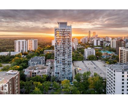 A tall building stands in the middle of a cityscape at sunset.