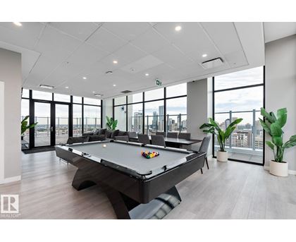 A spacious room with grey carpeting and a view of the street through the windows.