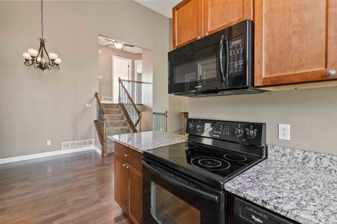 A kitchen with a black microwave above the stove.