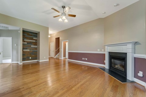 A living room with a fireplace and a ceiling fan.