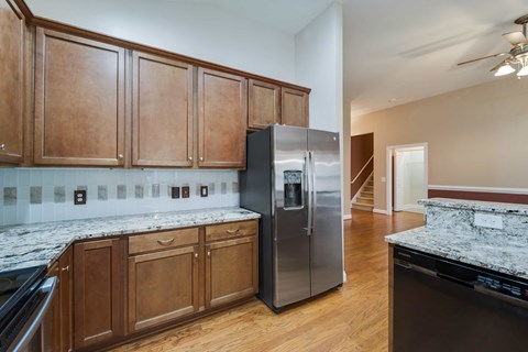 A kitchen with wooden cabinets and a marble countertop.