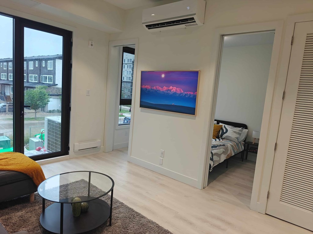 A living room with a flat screen TV mounted on the wall.