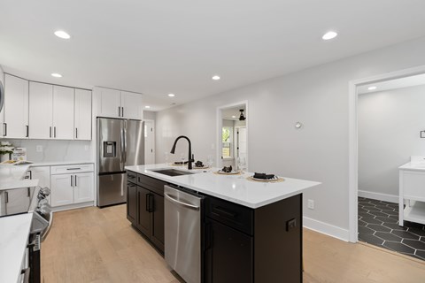 A modern kitchen with dark brown cabinets and a white countertop.