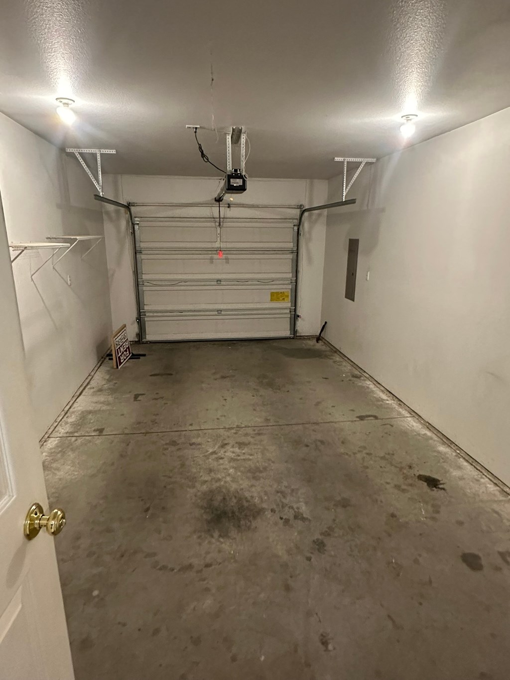 A garage with a white door and a white wall.