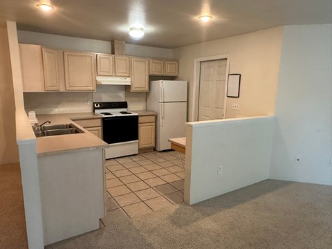 A kitchen with a white refrigerator and a white stove.