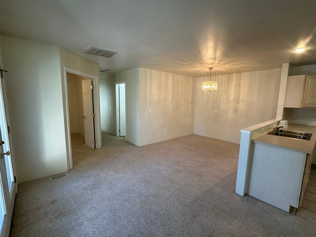 A spacious room with a kitchenette and a window.