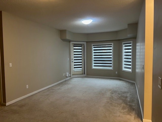 A room with a carpeted floor and a window with blinds.