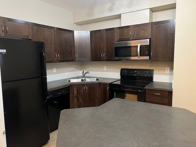 A black refrigerator is in a kitchen with brown cabinets.