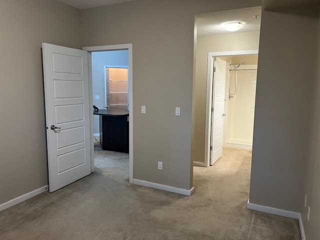 A room with a white door and carpeted floor.