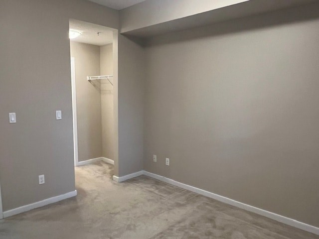 A room with a doorway leading to another room and a wall-mounted shelf.