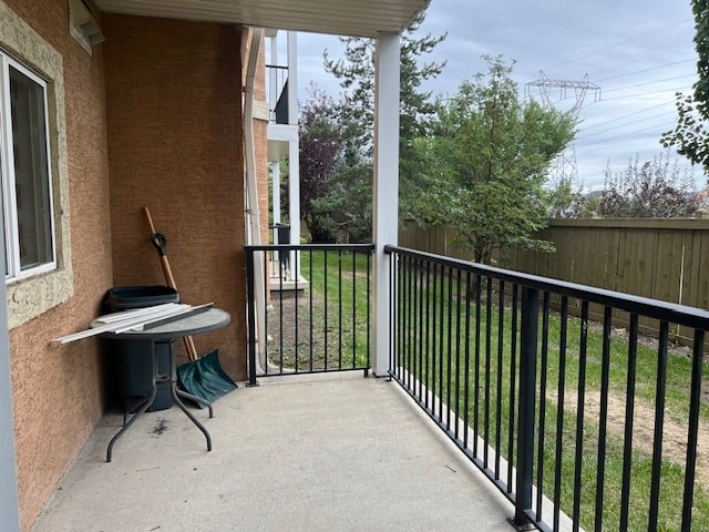 A patio with a black railing and a table with chairs.