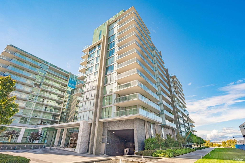 A modern multi-story building with a mix of glass and stone facades.