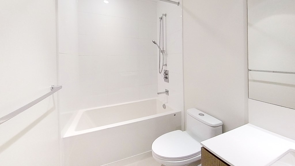 A white bathroom with a toilet, sink, and bathtub.