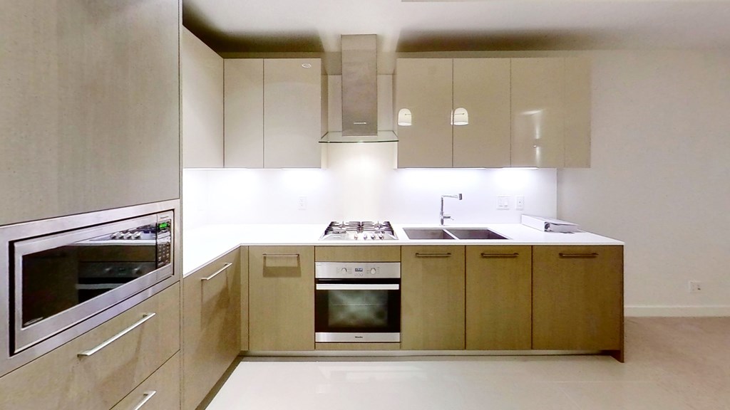 A modern kitchen with wooden cabinets and stainless steel appliances.