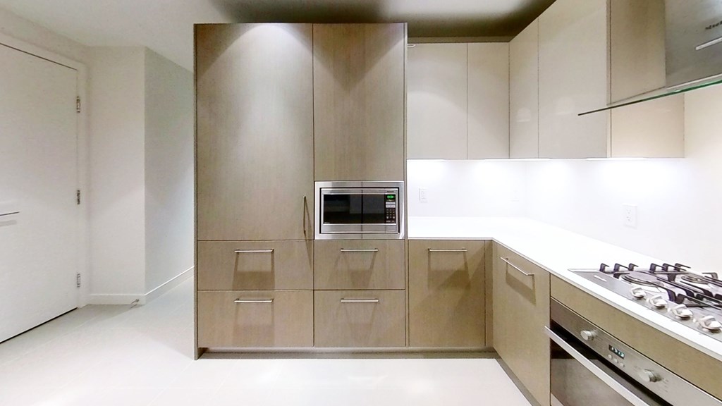 A modern kitchen with a stove and oven built into the cabinetry.