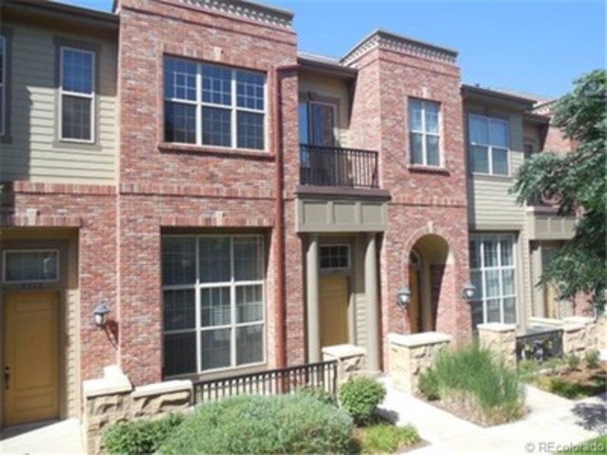 A row of townhouses with balconies and front yards.