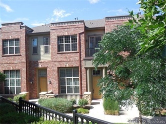 A row of houses with a black fence in front.